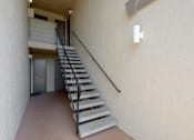 Thumbnail 33 of 37 - A staircase with a metal railing leads to a door.