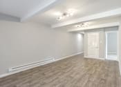 Thumbnail 13 of 27 - A room with wooden flooring and white walls.