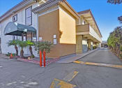 Thumbnail 5 of 35 - A street view of a building with a green awning and a yellow line on the road.
