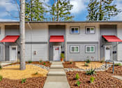 Thumbnail 2 of 53 - front view of a gray building with red awnings and a sidewalk