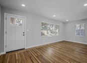Thumbnail 19 of 31 - A room with wooden flooring and white walls.
