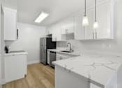 Thumbnail 48 of 92 - A kitchen with white cabinets and a marble countertop.