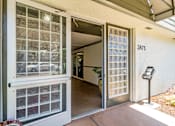 Thumbnail 27 of 43 - A glass door with a metal frame is open to a hallway.