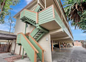 Thumbnail 10 of 14 - A house with a green staircase and a garage.