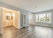 Thumbnail 37 of 42 - A large empty room with a window overlooking trees.