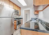 Thumbnail 29 of 52 - A kitchen with a stainless steel refrigerator and wooden cabinets.