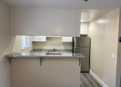 Thumbnail 18 of 43 - A kitchen with a granite countertop and stainless steel appliances.