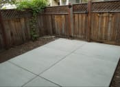 Thumbnail 14 of 22 - a stamped concrete patio in front of a wooden fence
