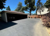 Thumbnail 4 of 19 - a car garage with a driveway in front of a house