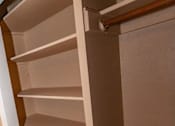 Thumbnail 23 of 25 - a closet with white shelves and a door