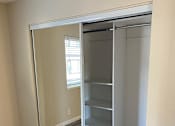 Thumbnail 31 of 43 - A large white closet with shelves and a mirror.
