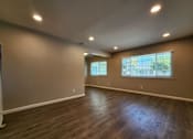 Thumbnail 30 of 50 - A spacious room with wooden flooring and two windows.