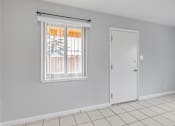 Thumbnail 24 of 38 - A room with a white door and a window with blinds.