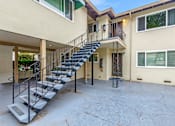 Thumbnail 20 of 43 - A staircase with a metal railing leads to a balcony.