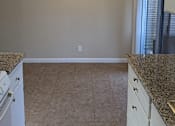 Thumbnail 35 of 36 - A kitchen with granite countertops and white cabinets.