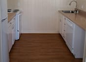 Thumbnail 9 of 44 - A kitchen with white appliances and wooden floors.