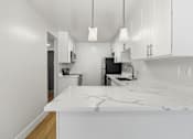 Thumbnail 60 of 92 - A kitchen with white cabinets and a marble countertop.