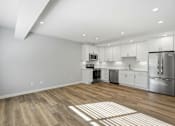 Thumbnail 66 of 67 - A kitchen with white cabinets and a wooden floor.