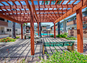 Thumbnail 17 of 25 - A wooden pergola with a bench underneath it.