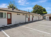 Thumbnail 24 of 31 - A row of houses with a parking lot in front.