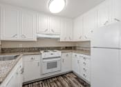 Thumbnail 45 of 51 - A white kitchen with a refrigerator on the right.