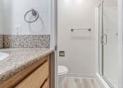 Thumbnail 27 of 29 - A bathroom with a toilet, sink, and shower.