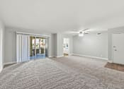 Thumbnail 10 of 33 - A spacious room with a carpeted floor and a ceiling fan.
