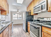 Thumbnail 31 of 52 - A kitchen with wooden cabinets and stainless steel appliances.