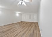 Thumbnail 45 of 52 - A room with a ceiling fan and wooden flooring.