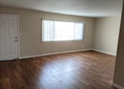 Thumbnail 16 of 42 - A room with wooden flooring and a window with blinds.