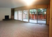 Thumbnail 14 of 38 - A living room with a flat screen TV and sliding glass doors.