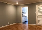 Thumbnail 26 of 47 - A room with wooden floors and a white door.