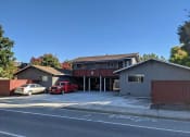 Thumbnail 4 of 36 - a house with a parking lot and a red car