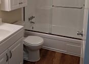 Thumbnail 39 of 42 - A white toilet sits under a mirror in a bathroom.