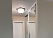 Thumbnail 32 of 36 - a hallway with mirrored doors and a light on the ceiling