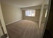 Thumbnail 15 of 23 - A room with a window and a carpeted floor.