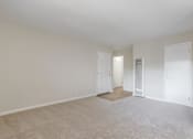 Thumbnail 18 of 37 - A large, empty room with carpeted flooring and white walls.
