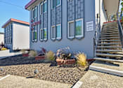 Thumbnail 22 of 29 - the front of a building with stairs and plants in front of it