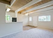 Thumbnail 17 of 32 - A spacious room with a wooden ceiling and a flat-screen TV mounted on the wall.