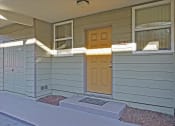 Thumbnail 9 of 35 - A small house with a brown door and a small porch.