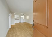 Thumbnail 8 of 38 - A room with a brown door and wooden flooring.