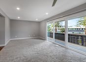 Thumbnail 14 of 53 - an empty living room with large windows and a balcony