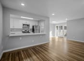 Thumbnail 4 of 31 - A kitchen with white cabinets and a wooden floor.