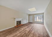 Thumbnail 20 of 21 - A room with a fireplace and wood flooring.