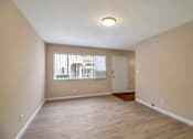 Thumbnail 3 of 13 - a spacious living room with wood floors and a window