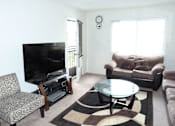 Thumbnail 14 of 15 - A living room with a flat screen TV and a glass coffee table.