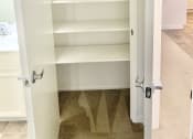 Thumbnail 3 of 26 - a closet with white shelves and a door open