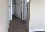 Thumbnail 11 of 31 - a room with a white door and a hallway with a door open