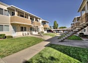 Thumbnail 7 of 33 - Apartment complex with a green lawn in front.