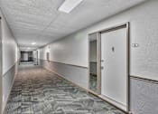 Thumbnail 28 of 41 - A long hallway with a door on the right.